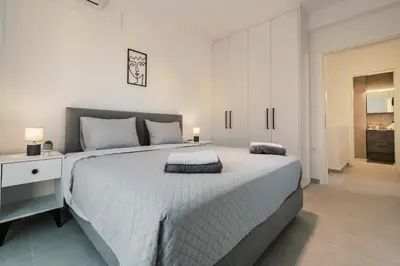a bedroom with a large white bed and a white cabinet at Koskinou Escape Villa in Koskinou
