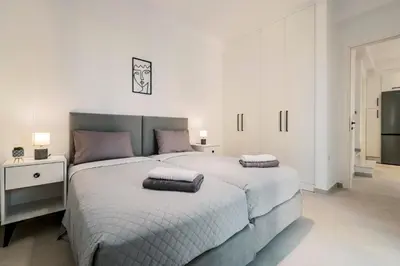 a white bedroom with two beds with pillows on them at Koskinou Escape Villa in Koskinou