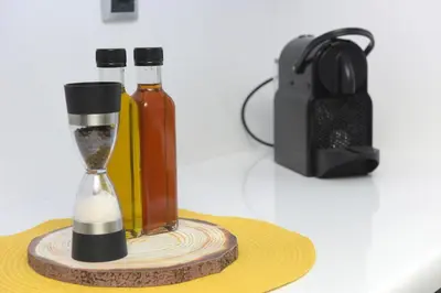 two bottles of alcohol and a sand timer on a table at Theros Lux Apartment in Émbonas