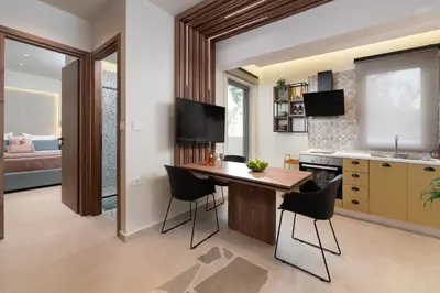 a kitchen with a wooden table and black chairs at Masarou Suites in Afantou