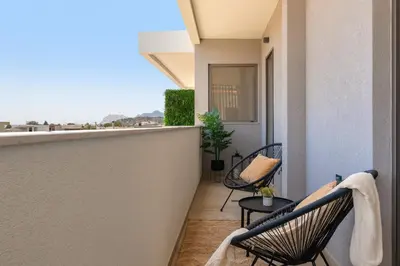 a balcony with chairs and a view of the city at Masarou Suites in Afantou