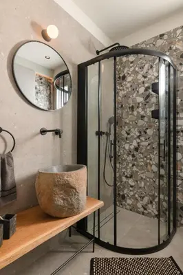 a bathroom with a shower and a bowl on a table at Masarou Suites in Afantou
