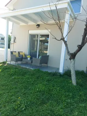 a patio with chairs and a tree on a house at Golden Sand 2 in Ialyssos