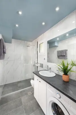 a bathroom with a sink and a washing machine at Golden Sand 2 in Ialyssos
