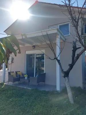 a house with chairs and a tree in the yard at Golden Sand 2 in Ialyssos