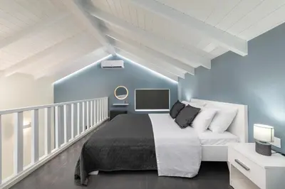 a bedroom with a large bed and blue walls at Golden Sand 3 in Ialyssos