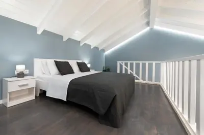 a bedroom with a large bed and blue walls at Golden Sand 3 in Ialyssos