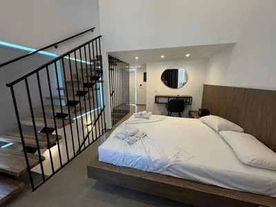 a bedroom with a large bed and a staircase at Delfinia Luxury Residence in Kolimbia