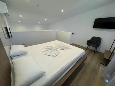 a bedroom with a white bed with a bow on it at Delfinia Luxury Residence in Kolimbia