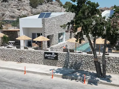 a building with a wall with umbrellas and a pool at Delfinia Luxury Residence in Kolimbia