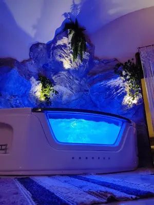 a swimming pool in a room with a rock wall at Ethnic Cave Suite in Rhodes Town