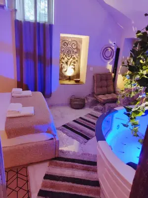 a living room with a tub and a room with purple at Ethnic Cave Suite in Rhodes Town