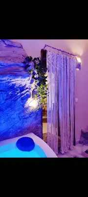 a bedroom with purple curtains next to a bed at Ethnic Cave Suite in Rhodes Town