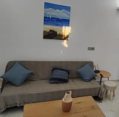 a living room with a couch and a painting on the wall at Villa Marina apartment Jasmine in Ixia