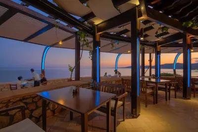 a restaurant with tables and a view of the ocean at Al Mare Villas in Kiotari