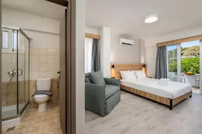 a hotel room with a bed and a bathroom at Colori Di Maria in Afantou