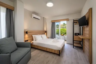 a hotel room with a bed and a couch at Colori Di Maria in Afantou