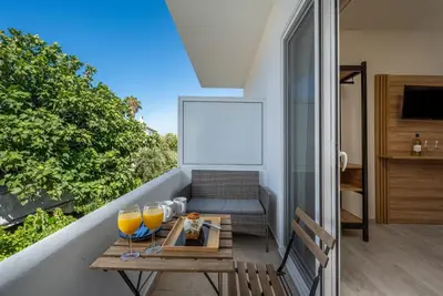 a balcony with a table and two glasses of orange juice at Colori Di Maria in Afantou