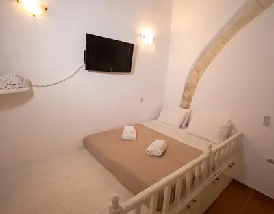 a bedroom with a bed with a tv on the wall at Villa Irini in Kallithea Rhodes
