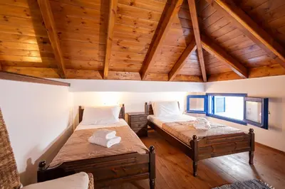 two beds in a room with wooden ceilings at Villa Irini in Kallithea Rhodes