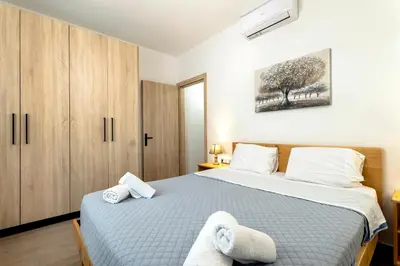 a bedroom with two beds and a painting on the wall at Reborn Luxury Apartments in Rhodes Town