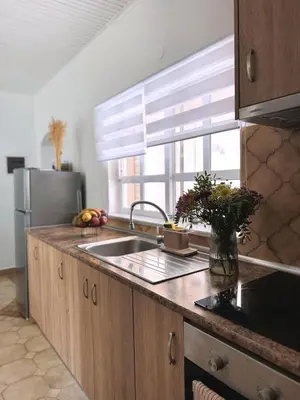 a kitchen with a sink and a refrigerator and a window at Nereid Bungalow in Phanaes