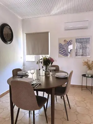 a dining room with a wooden table and chairs at Nereid Bungalow in Phanaes