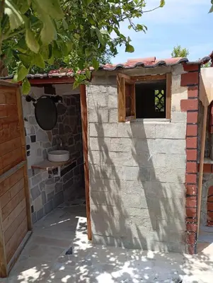 a small brick building with a window and a sink at Nereid Bungalow in Phanaes