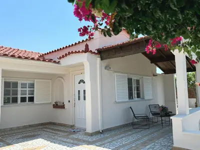 a house with a patio and a white door at Nereid Bungalow in Phanaes