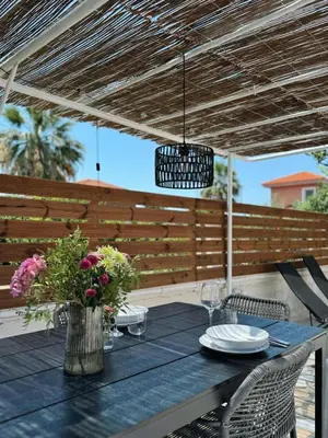 a table with a vase of flowers on a patio at Nereid Bungalow in Phanaes