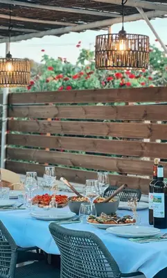 a table with plates of food on it with lights at Nereid Bungalow in Phanaes