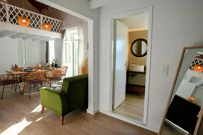 a living room with a green chair and a dining room at Bella Vista in Symi