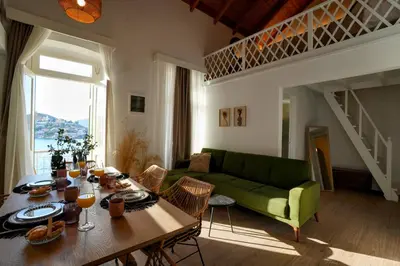a living room with a table and a green couch at Bella Vista in Symi
