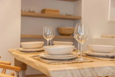 a wooden table with plates and wine glasses on it at The Villa Rhodes Retreat with Private Jacuzzi - Minutes away from Old Town in Rhodes Town