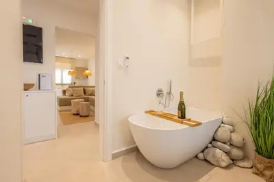 a white bathroom with a tub with a bottle of wine at The Villa Rhodes Retreat with Private Jacuzzi - Minutes away from Old Town in Rhodes Town