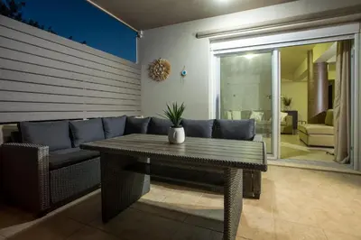 a living room with a table and a couch at Villa Frady in Kolimbia