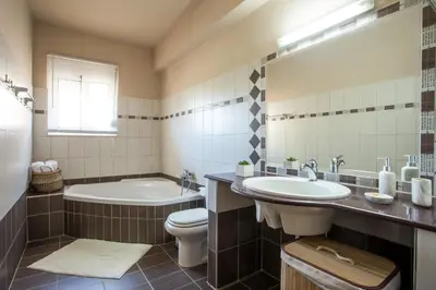 a bathroom with a tub and a toilet and a sink at Villa Frady in Kolimbia