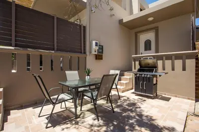 a patio with a table and chairs and a stove at Villa Frady in Kolimbia