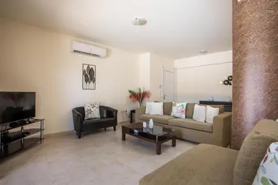 a living room with a couch and a tv at Villa Frady in Kolimbia