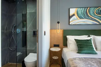 a bedroom with a shower and a bed and a toilet at Santa Marina Luxury Apartments #3 in Asgourou