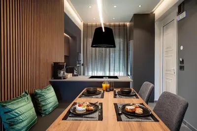 a dining room table with two plates of food on it at Santa Marina Luxury Apartments #3 in Asgourou