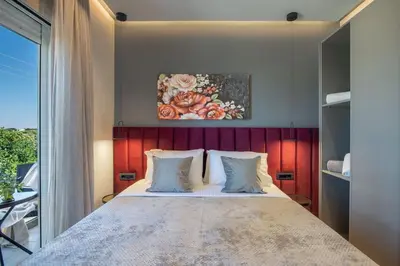 a bedroom with a large bed with a painting on the wall at Santa Marina Luxury Apartments #3 in Asgourou