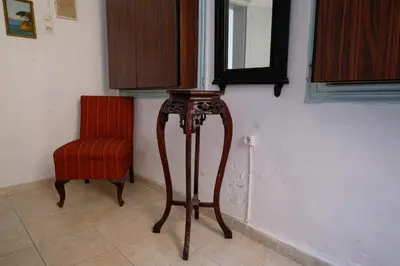 a room with a red chair and a mirror at Archontiko Pataka in Rhodes Town