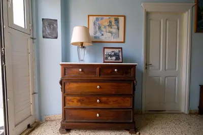 a dresser with a lamp on top of it in a room at Archontiko Pataka in Rhodes Town