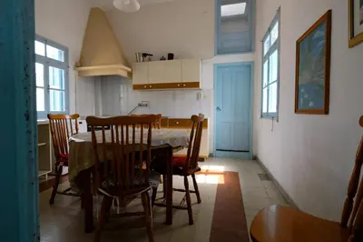 a kitchen with a table and chairs and a blue door at Archontiko Pataka in Rhodes Town