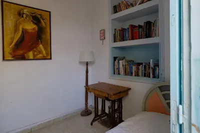 a bedroom with a bed and a table and bookshelves at Archontiko Pataka in Rhodes Town