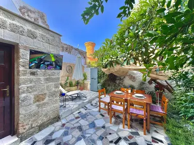 a patio with a wooden table and chairs on a patio at George&Michael Traditional House in Rhodes Town