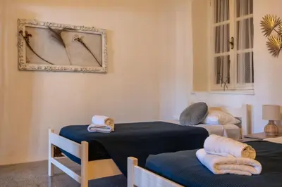a room with two beds and a mirror on the wall at George&Michael Traditional House in Rhodes Town