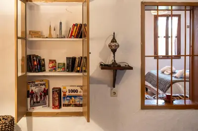 a room with a mirror and a shelf with books at George&Michael Traditional House in Rhodes Town