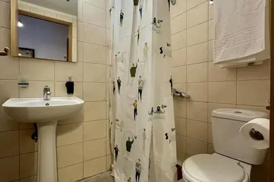 a bathroom with a shower curtain with a toilet and a sink at George&Michael Traditional House in Rhodes Town